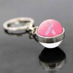 Macro shot of silver keychain featuring a pink floral ribbon charm for breast cancer awareness