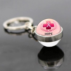Macro shot of glass dome keychain with pink ribbon hope symbol and metal ring details