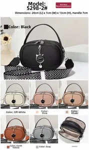 Detail of plaid leather crossbody bag with cat-shaped metal charm and wide woven strap