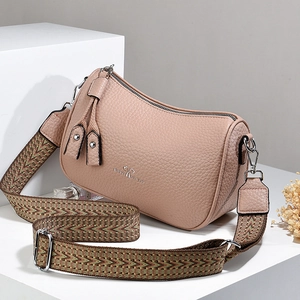 Borsa a cilindro in pelle rosa con tracolla ricamata su display geometrico moderno