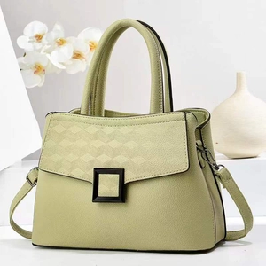 Detail of light green faux leather tote with V-pattern stitching and black matte buckle