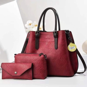 Détail d'un ensemble trois pièces avec cabas, pochette et portefeuille en cuir bordeaux