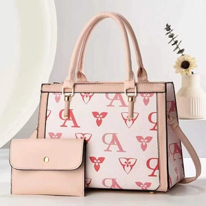 Pink and beige patterned tote bag set with matching clutch and golden hardware accents