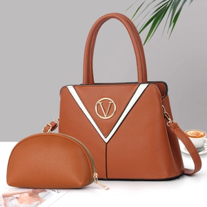 Détail d'un sac à main marron avec logo V en métal et rayures contrastées en noir et blanc