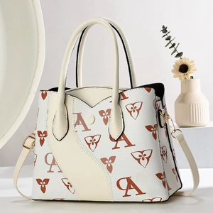 Détail d'un sac en cuir crème avec imprimés marrons et accessoires en métal doré