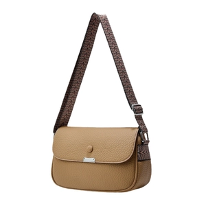 Brown leather crossbody bag with geometric woven strap and silver hardware on white background