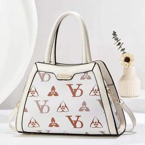 Macro view of beige crossbody bag with premium brown print pattern and golden clasp