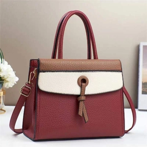 Detail of color-block tote bag featuring lychee grain texture and knot decoration