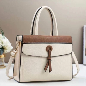 Detail of color-block tote bag featuring lychee texture and decorative ring handle