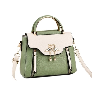 Litchi pattern leather handbag with color blocking and swan clasp on white background