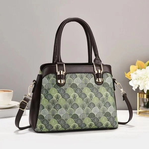 Close-up of green fish scale pattern texture and golden hardware on handbag