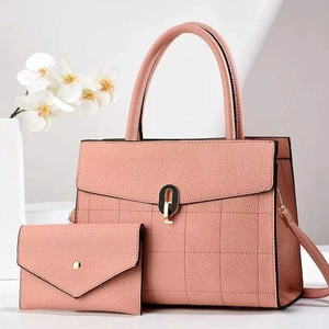 Detail of pink plaid stitched tote bag with matching envelope clutch and arch lock