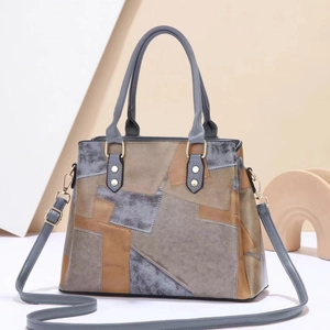 Detail der Vintage-Patchwork-Handtasche mit matter Lederstruktur und Goldbeschlägen