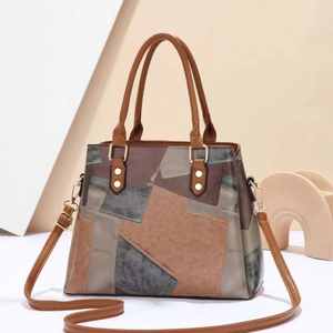 Detailaufnahme der großen Color-Block-Tasche mit Goldnieten und abnehmbarem Gurt