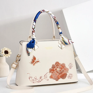 Elegante borsa ricamata beige con motivi floreali e farfalle e manico in seta fine