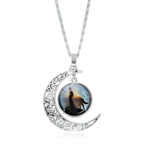 Détail du collier croissant de lune argenté avec pendentif silhouette loup et femme