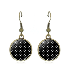 Close-up of vintage bronze polka dot drop earrings with glossy glass dome covers