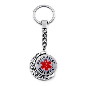 Close-up of rotating silver medical alert keychain with red star of life for diabetics