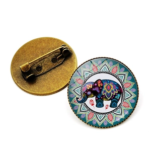 Detailed front and back view of a round elephant mandala brooch with antique bronze finish