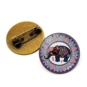 Detail of elephant and floral glass brooch with vintage bronze pin back and safety clasp