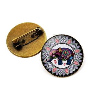 Detailed view of bohemian elephant brooch with bronze pin back and glass mandala dome