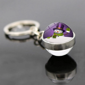Detail view of snowman glass ball keychain with festive winter illustration and metal ring