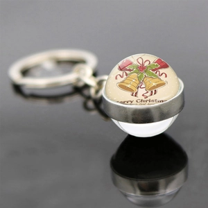 Macro view of double-sided glass Christmas bell keychain with Merry Christmas text