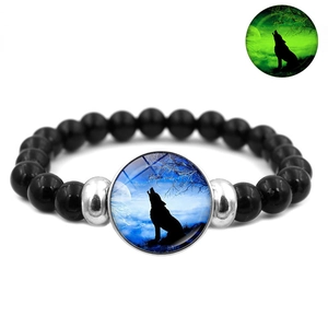 Detail showing the howling wolf glowing effect on a black beaded elastic bracelet