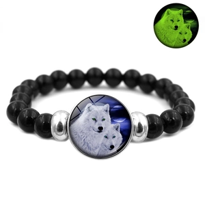 Glow-in-the-dark beaded bracelet featuring a howling wolf glass dome and green luminous effect