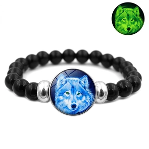 Detailed close-up of a glowing wolf moon bracelet with black beads and luminous glass charm