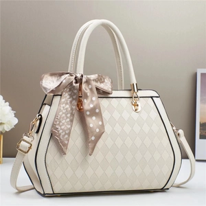 Chic white quilted tote bag with gold metal handles and stylish patterned scarf detail