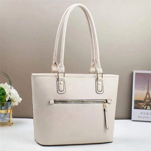 Detail showing the cream bucket tote bag with textured leather and metal zipper pocket