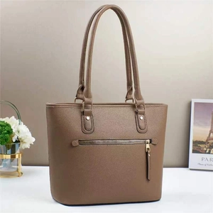 Close-up of brown lychee grain leather bucket bag with gold zipper and dual handles