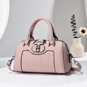 Detail of pink plaid Boston bag featuring a double-T metal clasp and round top handles