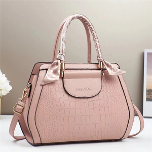 Pink crocodile embossed tote bag with scarf-wrapped handle and golden hardware details