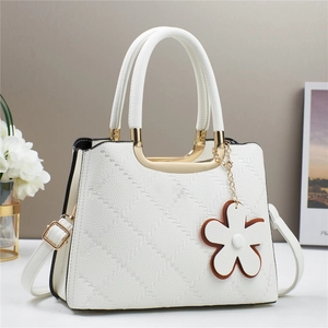 Elegant white quilted tote bag with macaron finish, dual handles and a floral pendant