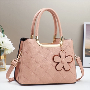 Pink quilted leather tote bag with top handles and a flower charm for daily commuting