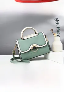 Detail of sage green and beige patchwork handbag with gold round buckle and top handle