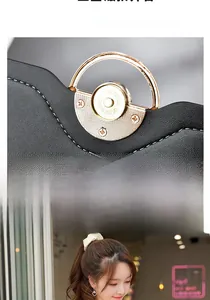 Close-up of black textured leather handbag with a round light gold magnetic buckle