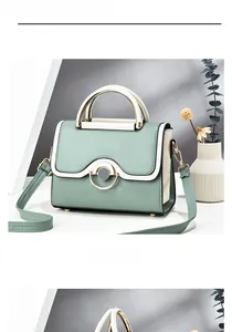 Detail of mint green and beige crossbody bag with metal handle and ring buckle lock