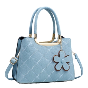 Light blue quilted tote bag with lychee texture, gold hardware, and flower charm