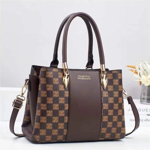 Detail of color-block tote bag with checkered texture and premium gold hardware