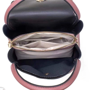 Detail view of pink leather bag interior with zipper pocket and gray chevron lining