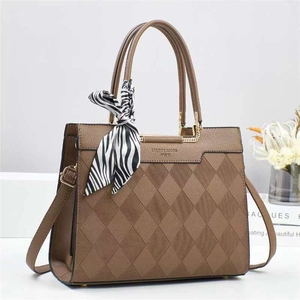 Detail of brown quilted bucket bag featuring a zebra silk scarf and gold hardware accents