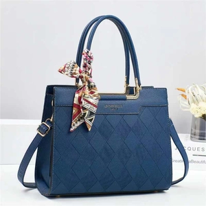 Navy blue quilted leather bucket bag with gold hardware and stylish silk scarf detail