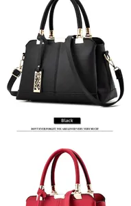 Close-up of a stylish lychee grain handbag with golden hardware and leaf charm pendant