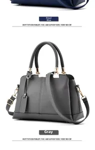 Close-up of gray leather handbag showing lychee texture and golden hardware details