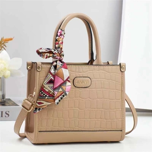 Dettaglio borsa tote in pelle goffrata coccodrillo con foulard e logo inciso
