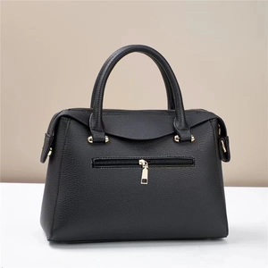 Detail view of the black pebble leather bucket bag showing the back zipper and gold hardware