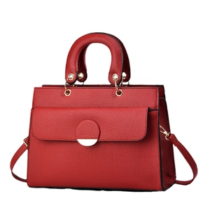 Red pebbled leather handbag for women featuring a gold buckle and detachable shoulder strap